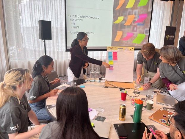 APIGA 2024 students workshopping a new idea using sticky notes.
